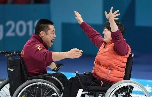 图为轮椅冰壶队员在比赛获胜后庆祝